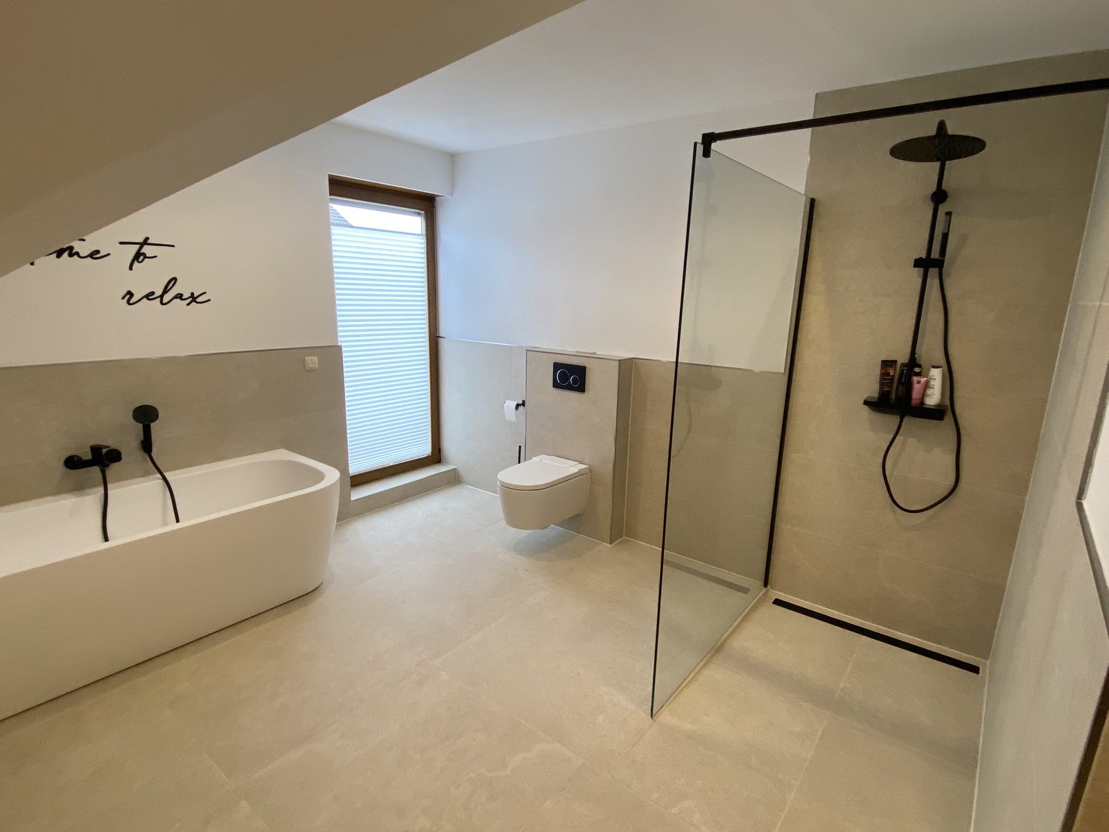 Modernes Bad mit freistehender Wanne und schwarzen Akzenten